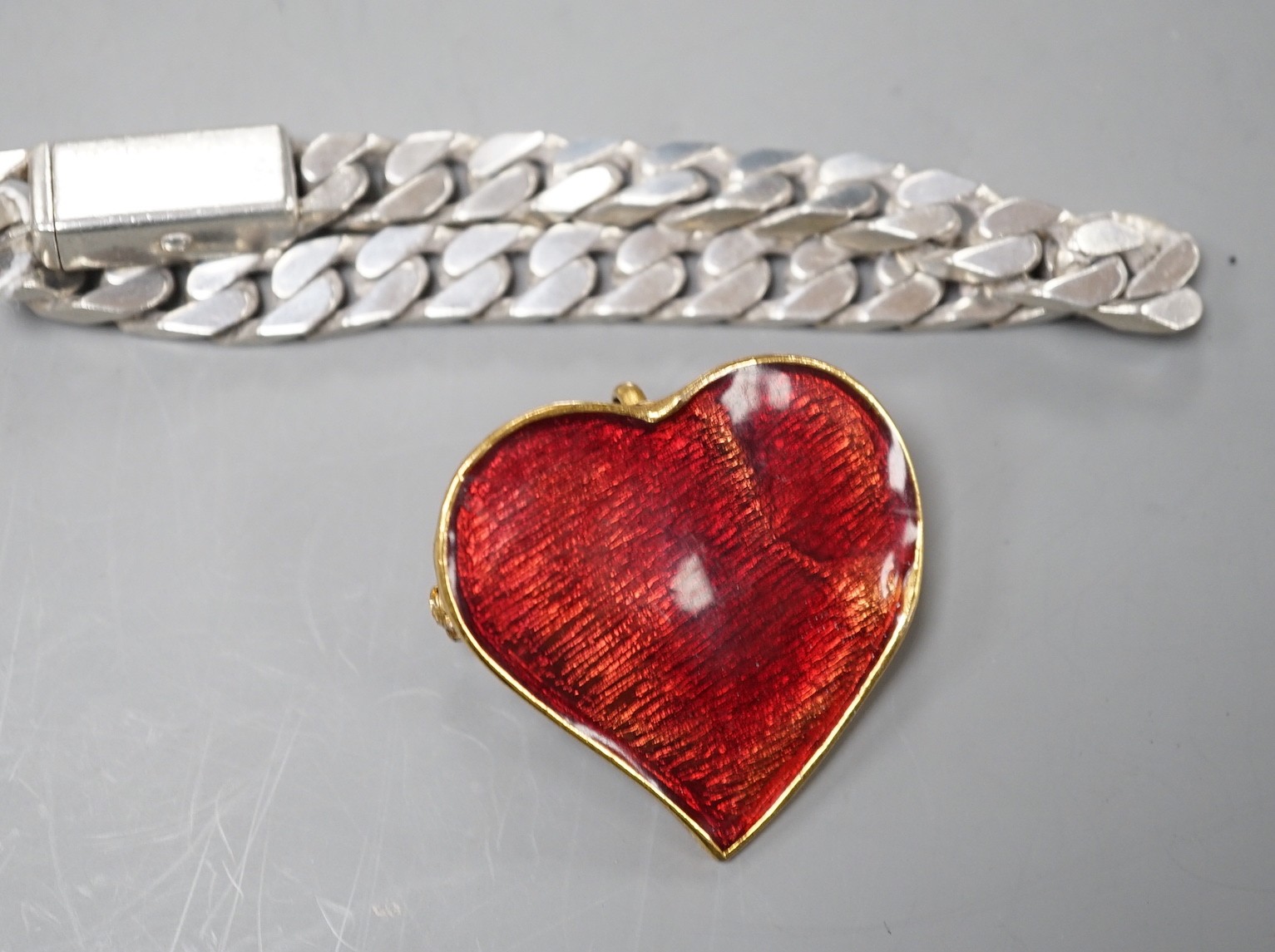 A modern Italian Gucci 925 curb link bracelet, approximately 20cm, together with an Yves Saint Laurent enamelled gilt metal heart shaped pendant brooch, 40mm.